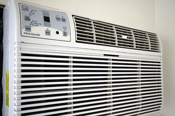 A white Frigidaire air conditioner sits in a corner.