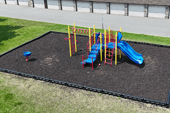A playground with a blue slide and a red and yellow climbing frame.