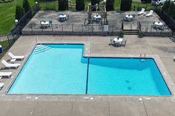 A large blue swimming pool surrounded by a black fence.
