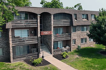 Apartment building exterior is shown with a green lawn in front.