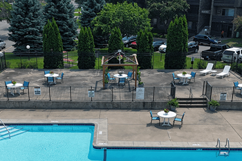 A pool with chairs and a table around it.