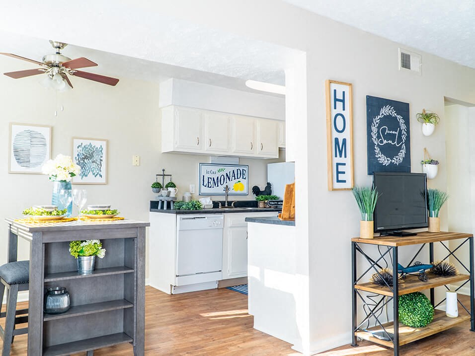 a kitchen and living room with a ceiling fan