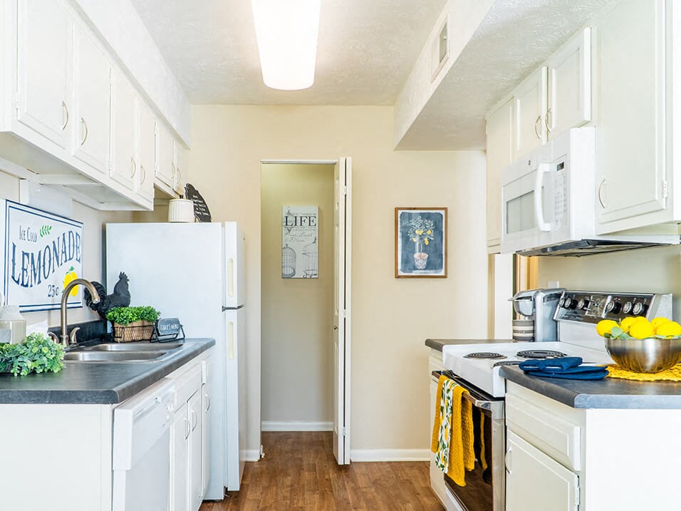 a kitchen with white cabinets and white appliances
