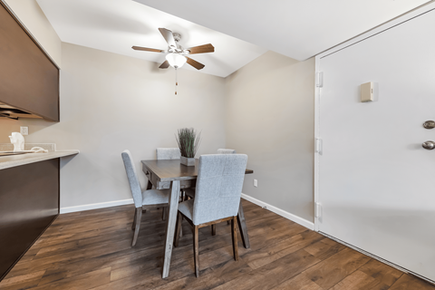 A dining room with a table and chairs.