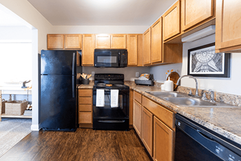 a kitchen with black appliances and wooden cabinets