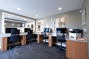 a computer room with desks and chairs and computers and monitors