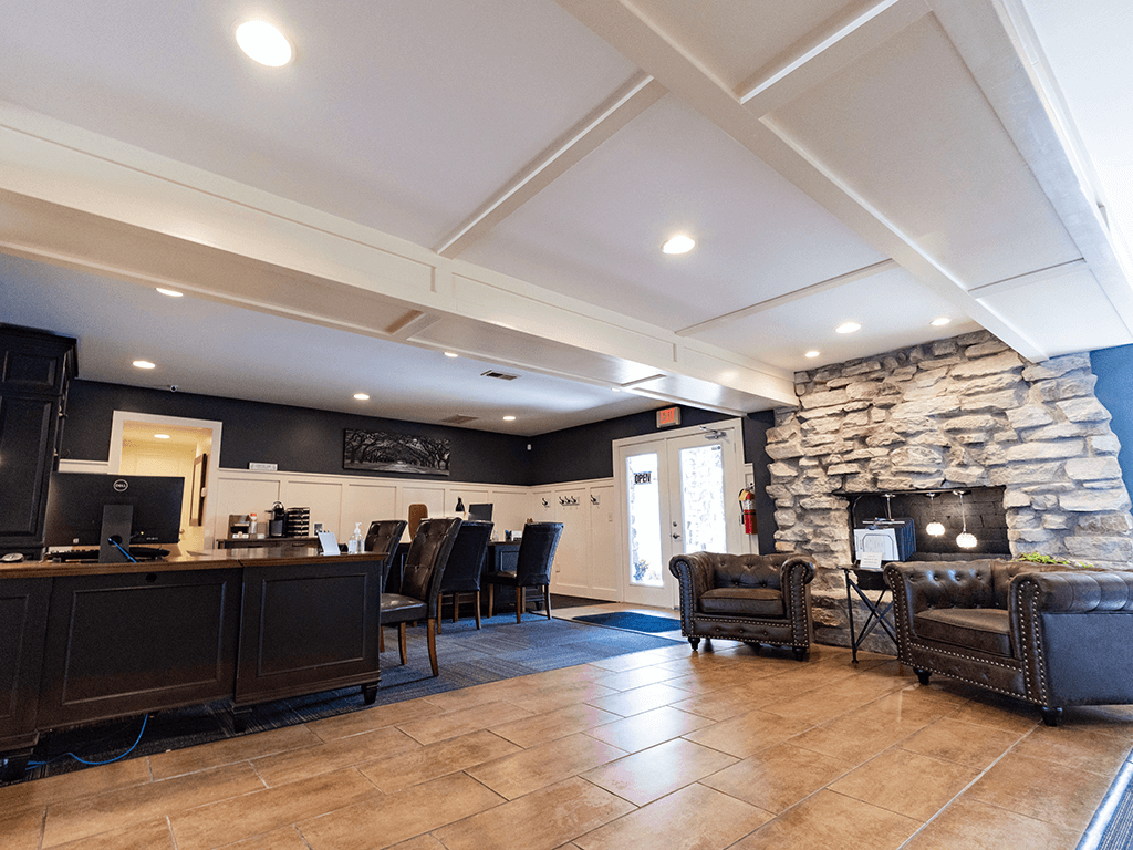 a lobby with a stone fireplace and a desk with chairs