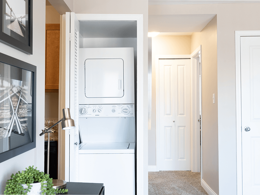 an in-home laundry room with a washer and dryer and a closet with a door