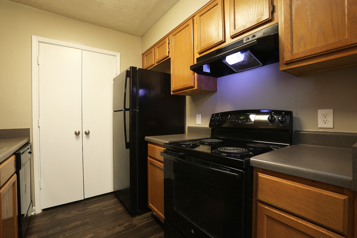 a kitchen with a black stove and a refrigerator