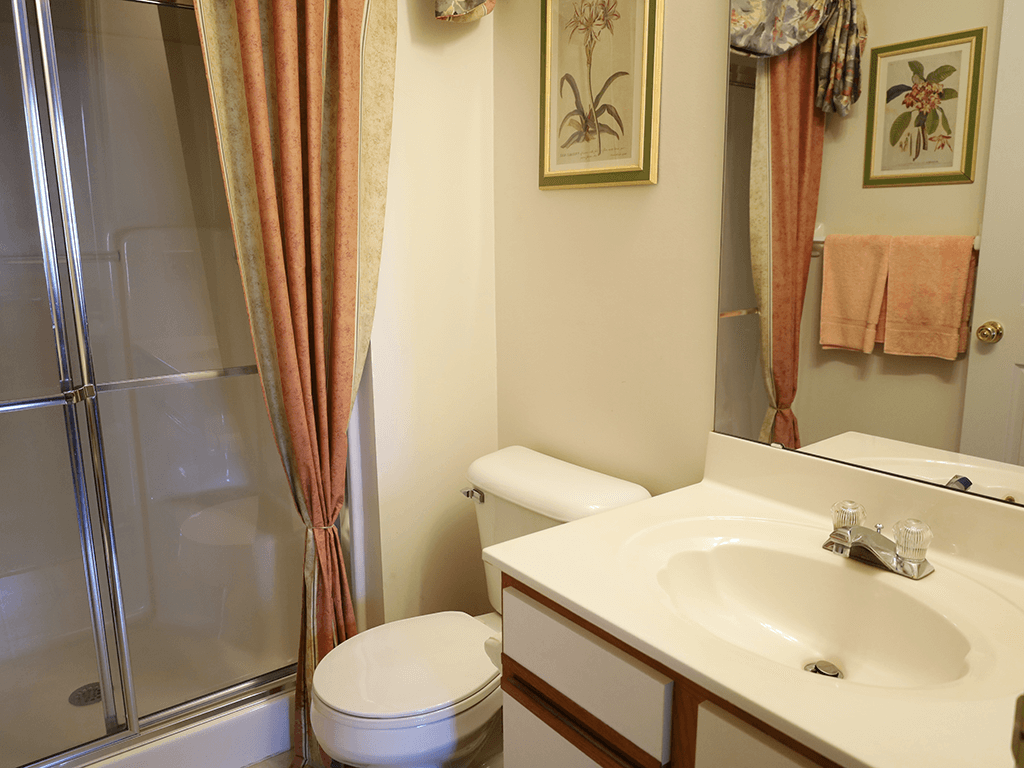 apartment bathroom with a sink, toilet, and shower