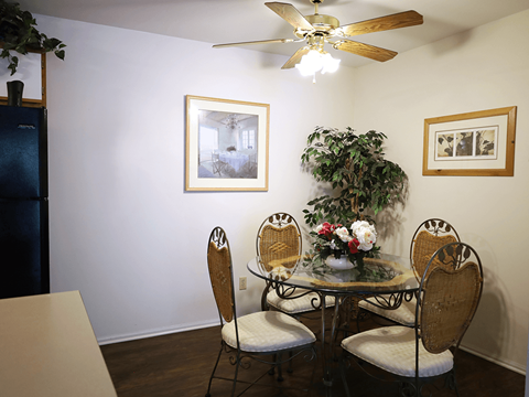 a dining room with a table and chairs and a ceiling fan