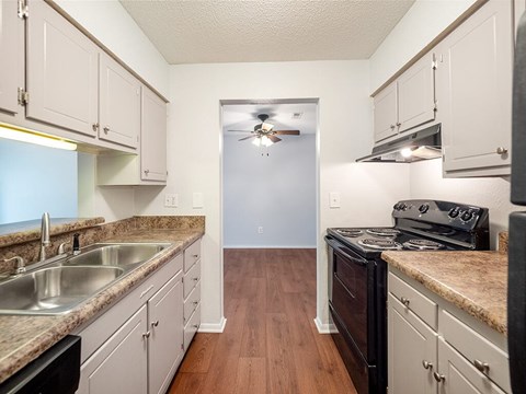 A kitchen with white cabinets and a black stove top oven.