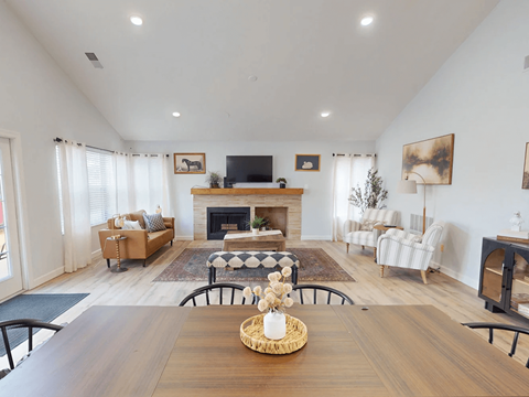 A living room with a fireplace and a television on the wall.