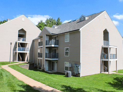 Apartment complex with a walkway in front.