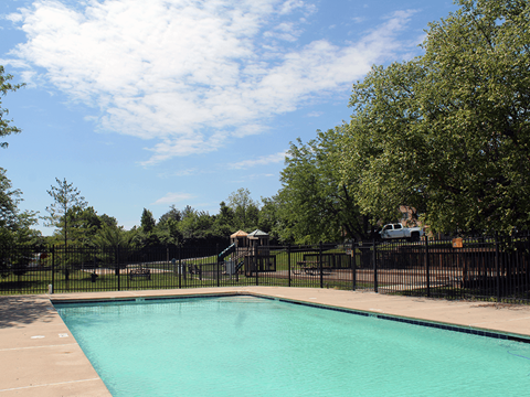 A small pool surrounded by a black fence.