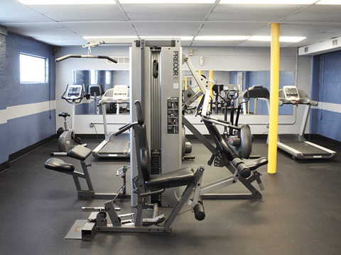 Apartment community gym with a variety of equipment including weight machines