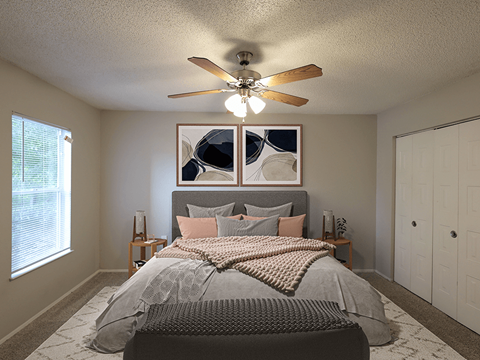 A bedroom with a large bed and a ceiling fan.