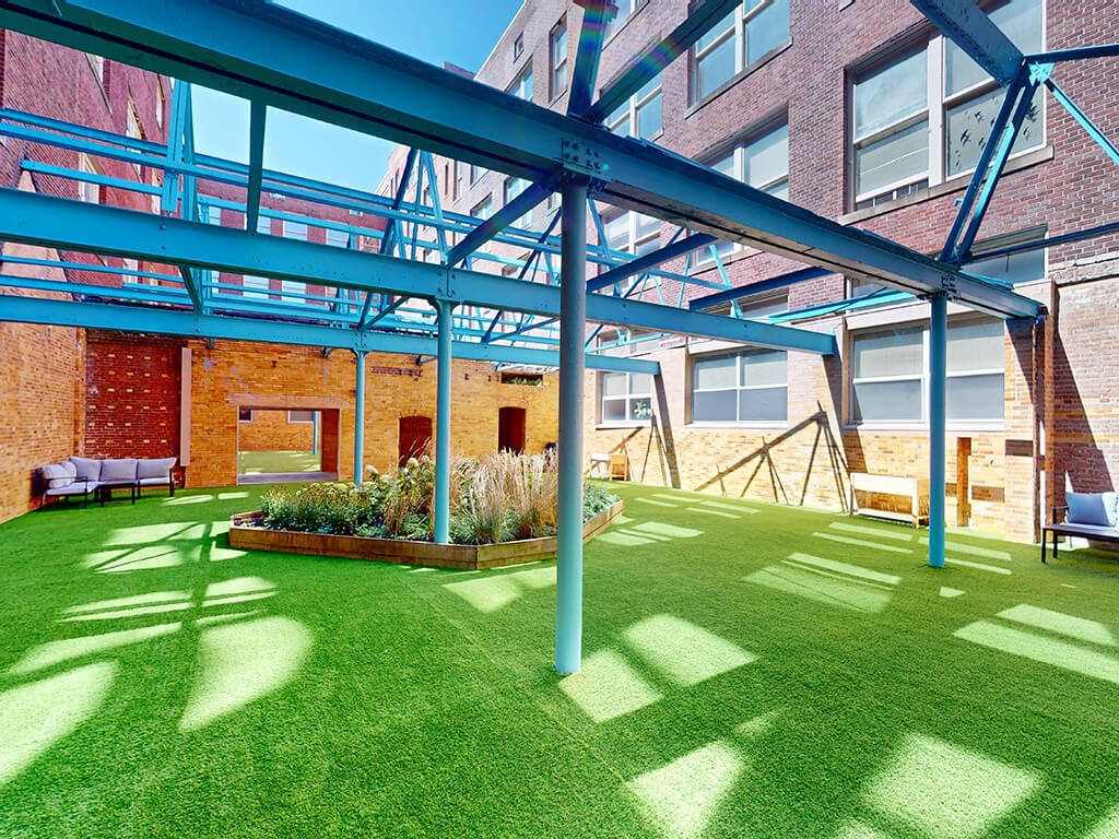 A green lawn with a blue metal frame structure above it.