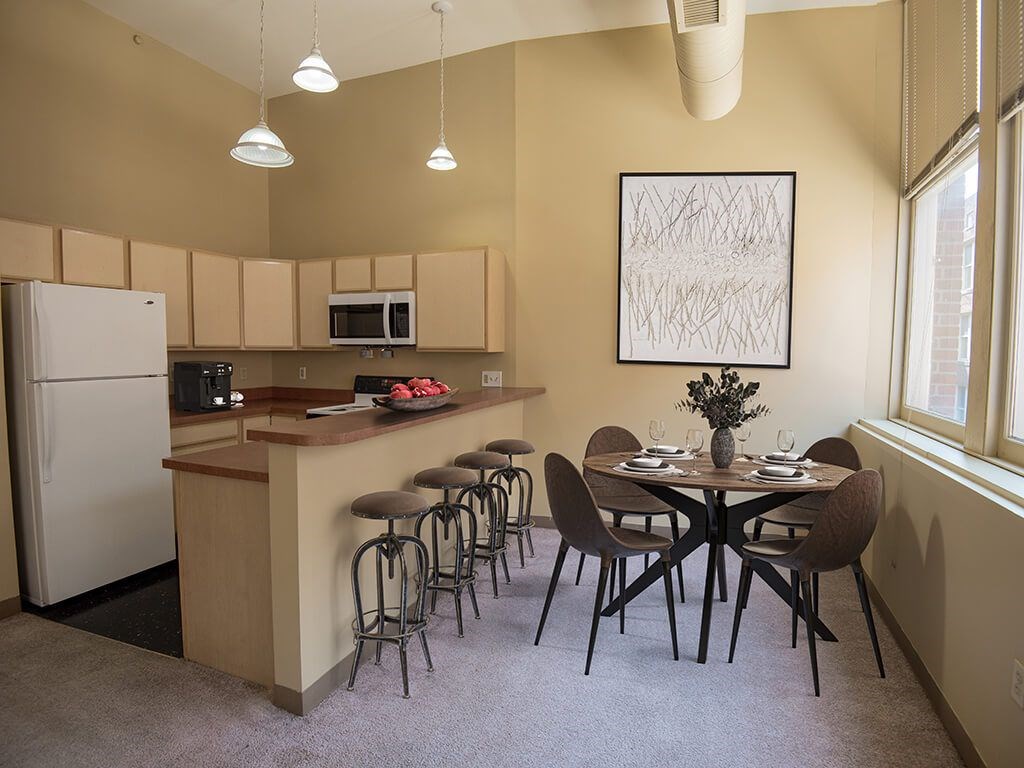 A kitchen with a table and chairs.