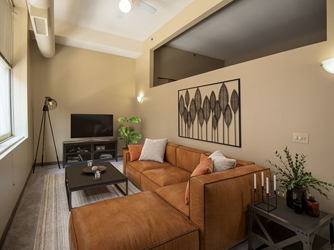 A living room with a brown couch and a black coffee table.