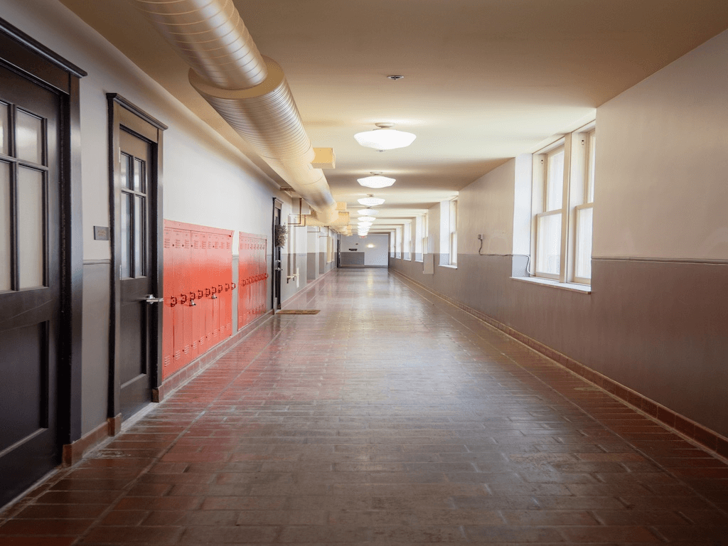 A long corridor with doors on the left and windows on the right.