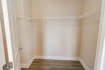 A small, empty room with a door on the left and a shelf on the right.