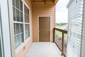 A brown door is on the side of a house.