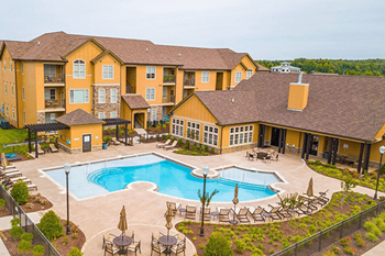 A large building with a pool in front of it.