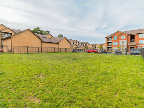 grassy dog park in front of apartment buildings