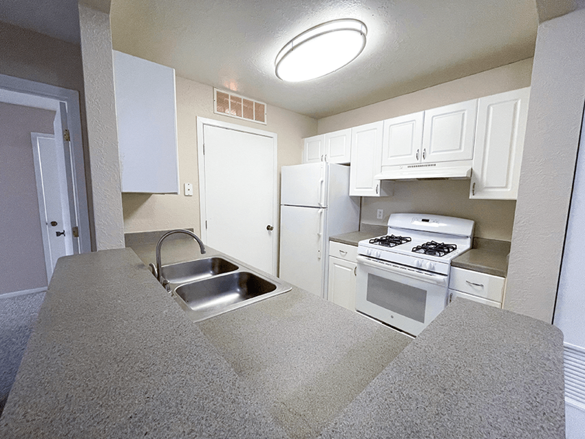 a kitchen with white cabinets and white appliances