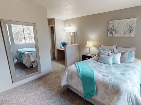 A bedroom with a large bed and a mirror on the wall.