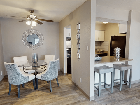 A modern dining room with a glass table and chairs.