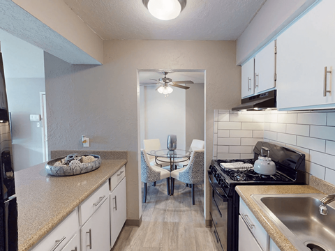 A kitchen with a black stove top oven and a white refrigerator.