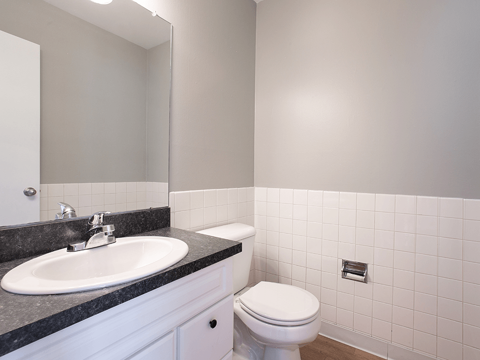 half bathroom with mirror and grey and white details