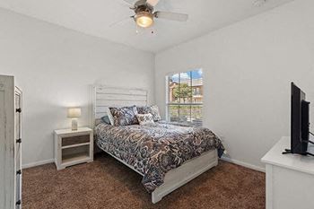 a bedroom with a bed and a ceiling fan