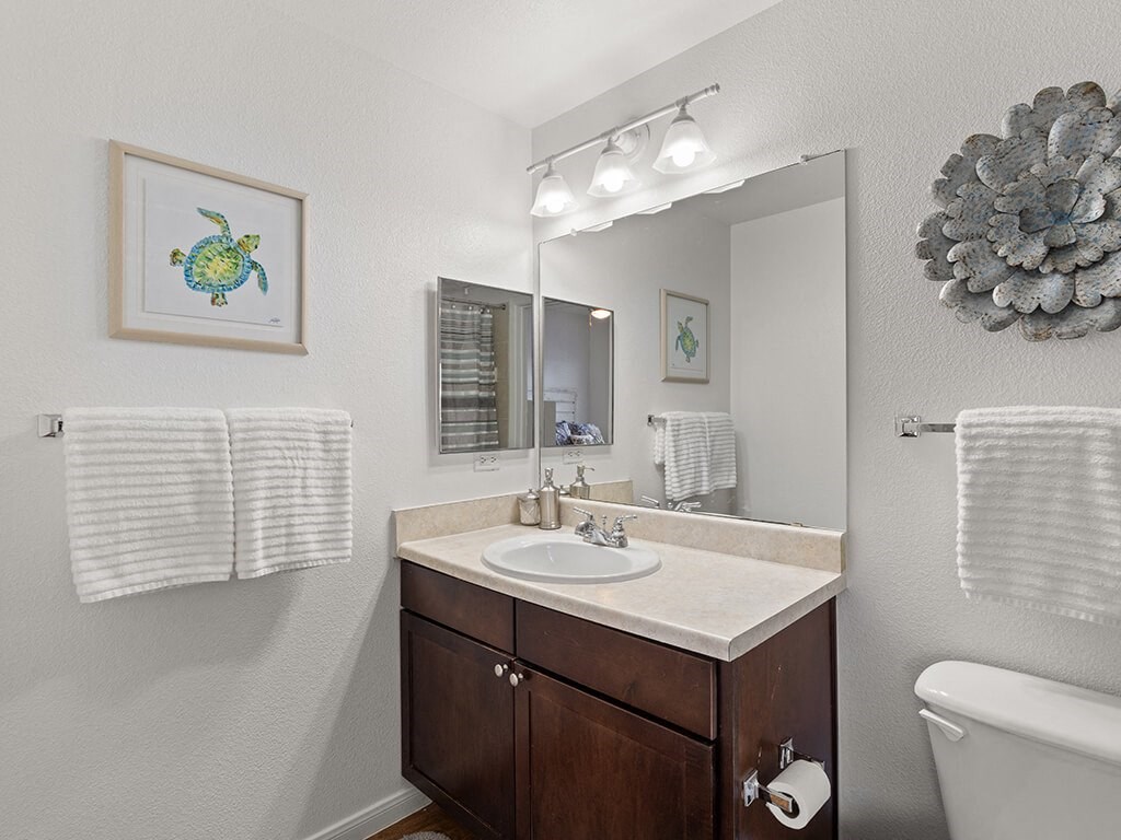 A bathroom with a white tub, sink, and towel rack.