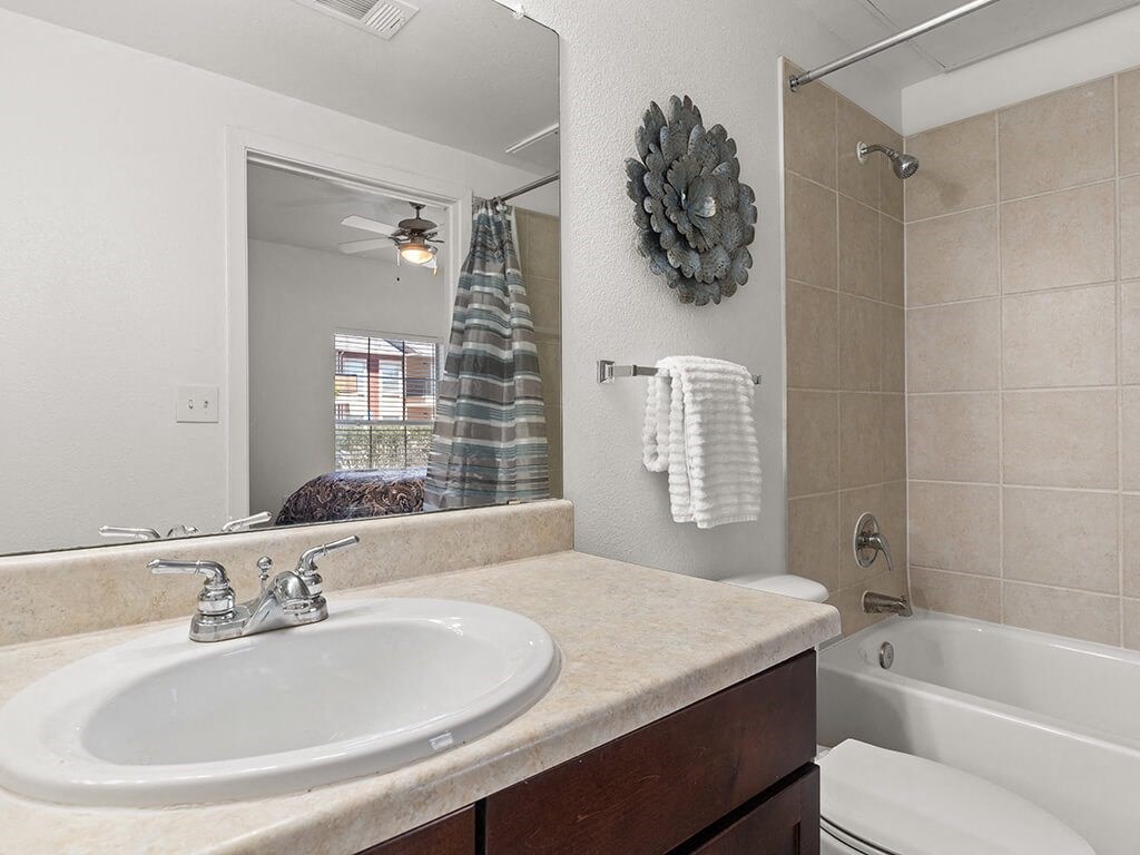 A bathroom with a white sink and a white tub.