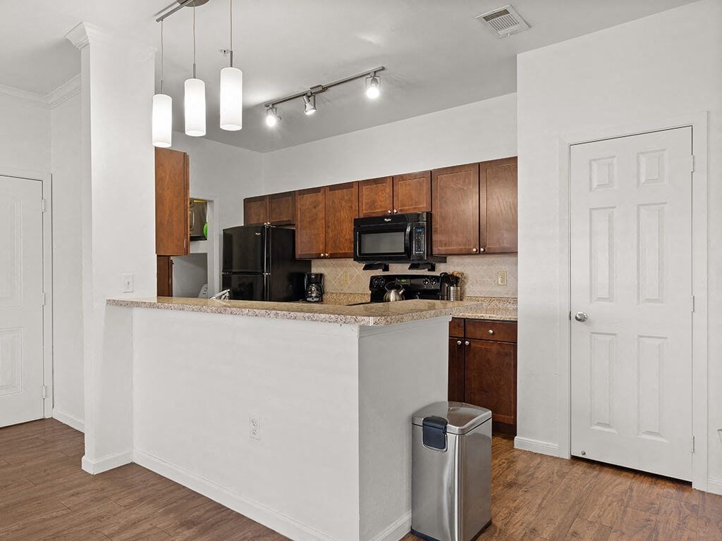 A kitchen with a white counter and brown cabinets.