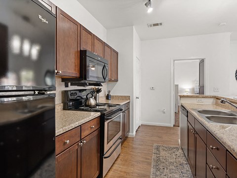 A kitchen with dark brown cabinets and stainless steel appliances.