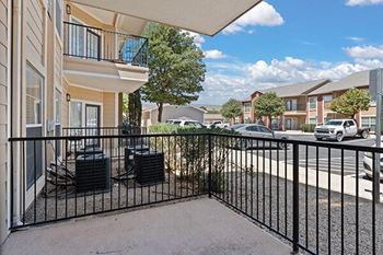 a patio with two chairs on the balcony of an apartment building