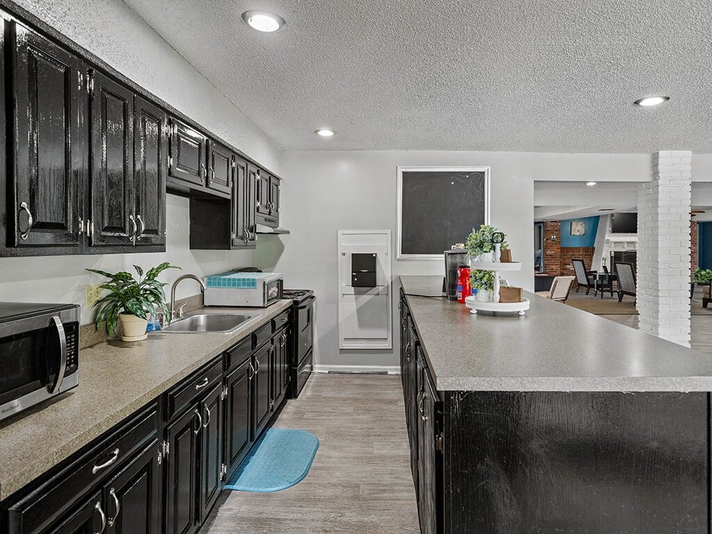 clubhouse kitchen with cabinets and a counter top