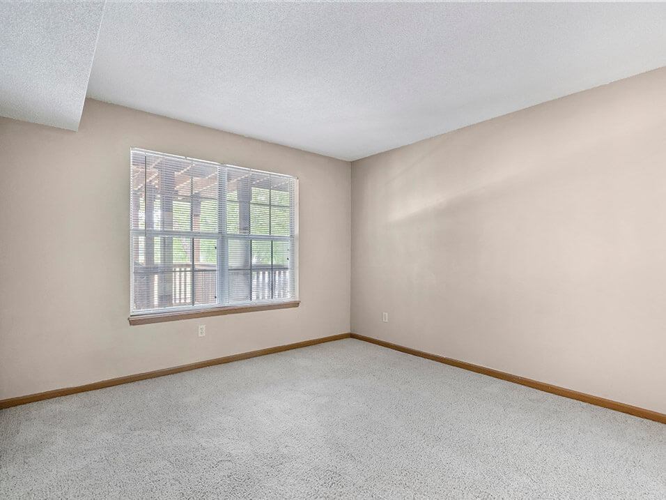 an empty bedroom with a large window