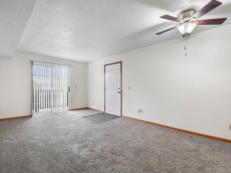apartment living room with a ceiling fan and a door to a balcony