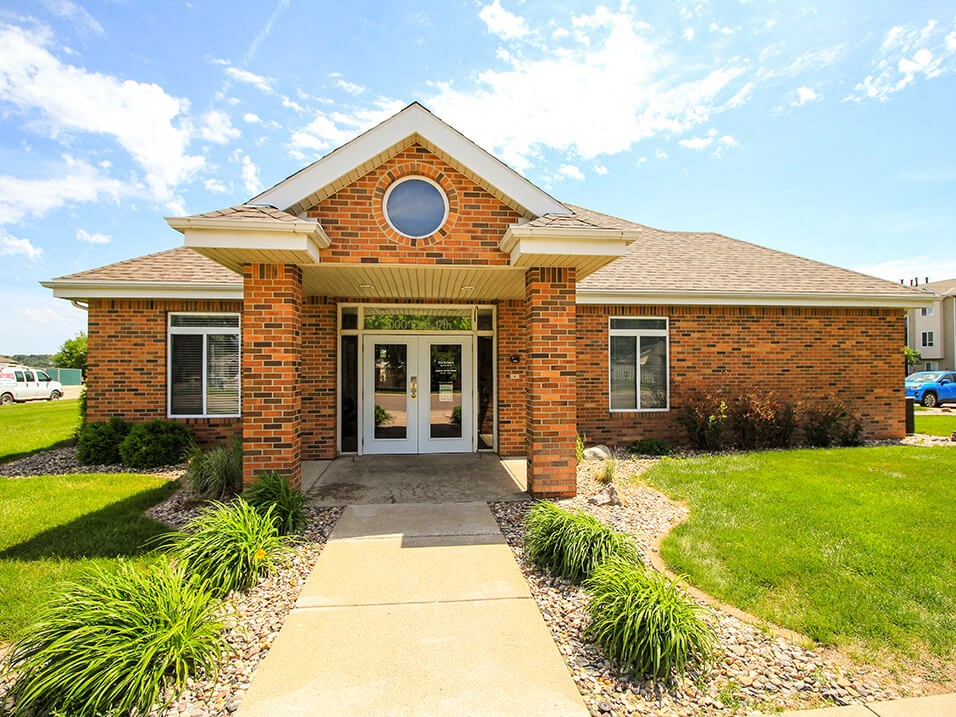 the front of a brick house with a walkway leading to the front door
