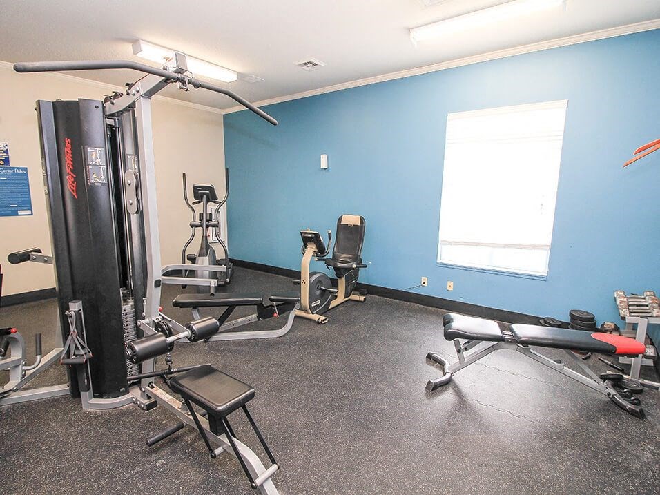 a room with a lot of exercise equipment and a window