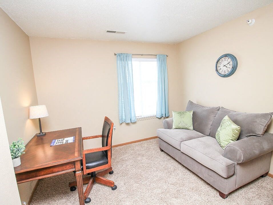 a living room with a couch and a desk
