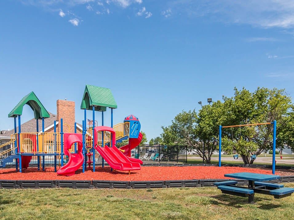 a playground with a picnic table and picnic table in front of it