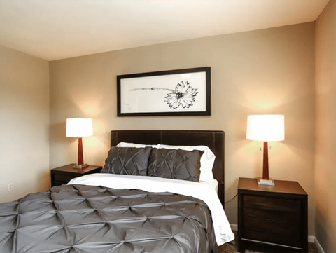 a bedroom with a bed and two lamps