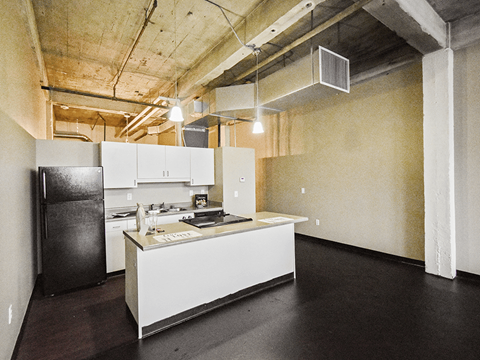 a kitchen with a white counter top and a black refrigerator