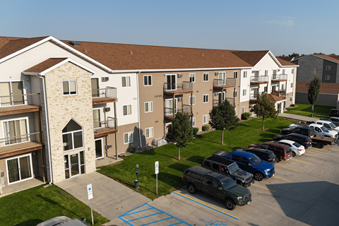 A parking lot in front of apartment buildings.